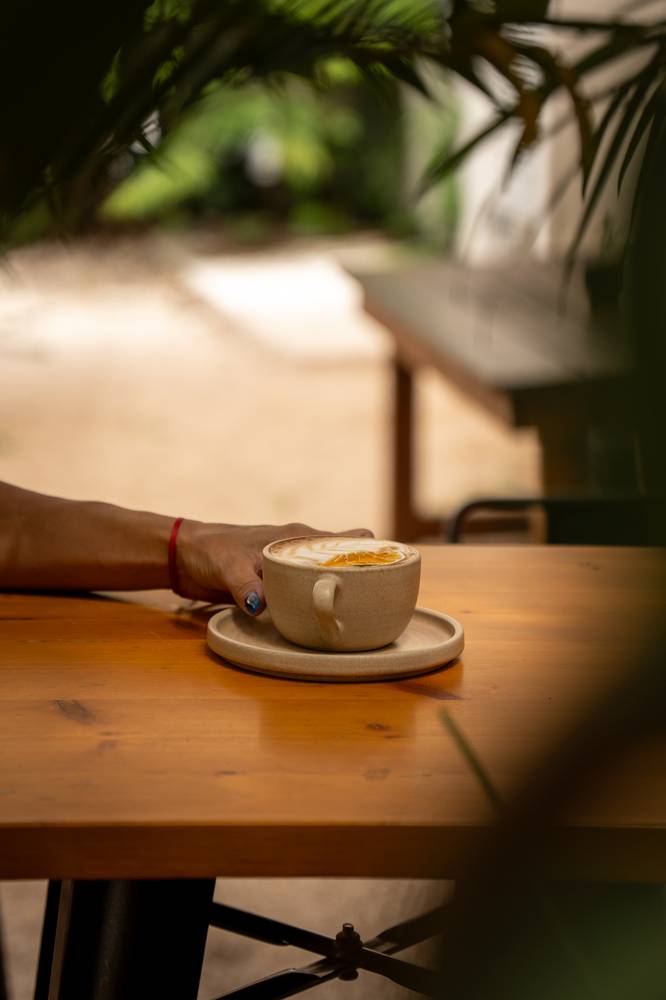 Café con leche sobre una mesa de madera en Nimai